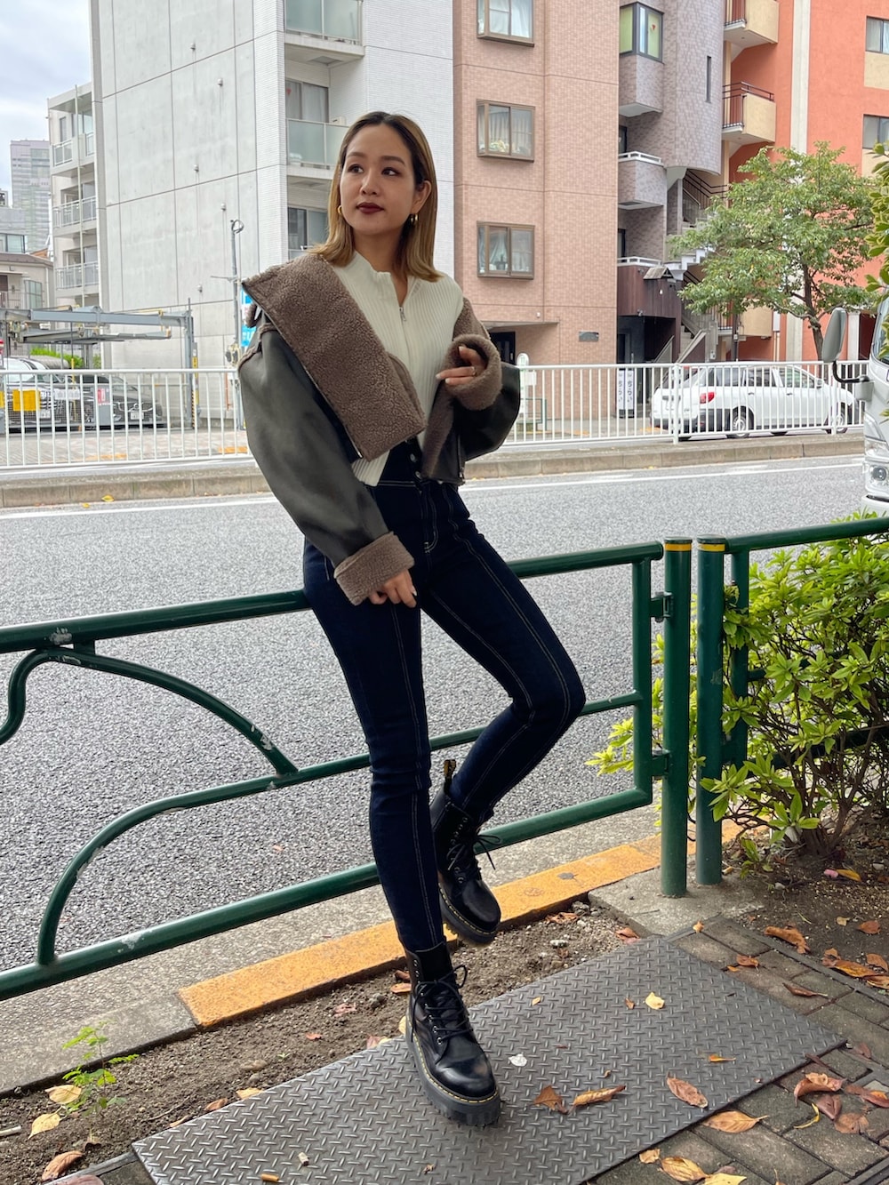 ブラック系のブーツ、ホワイト系のニット/セーター、グリーン系のブルゾンを着用したレディースの秋コーディネートの2枚目の写真