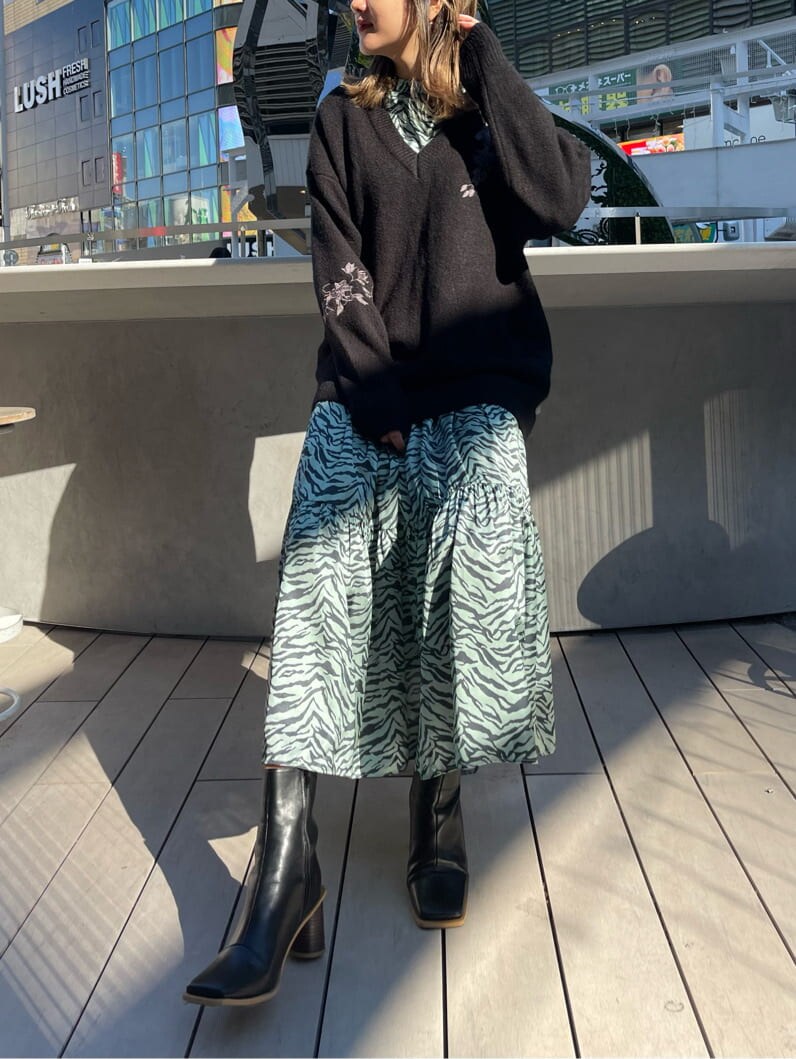 ブラック系のブーツ、グリーン系のワンピース、ブラック系のニット/セーターを着用したレディースの冬コーディネートの3枚目の写真