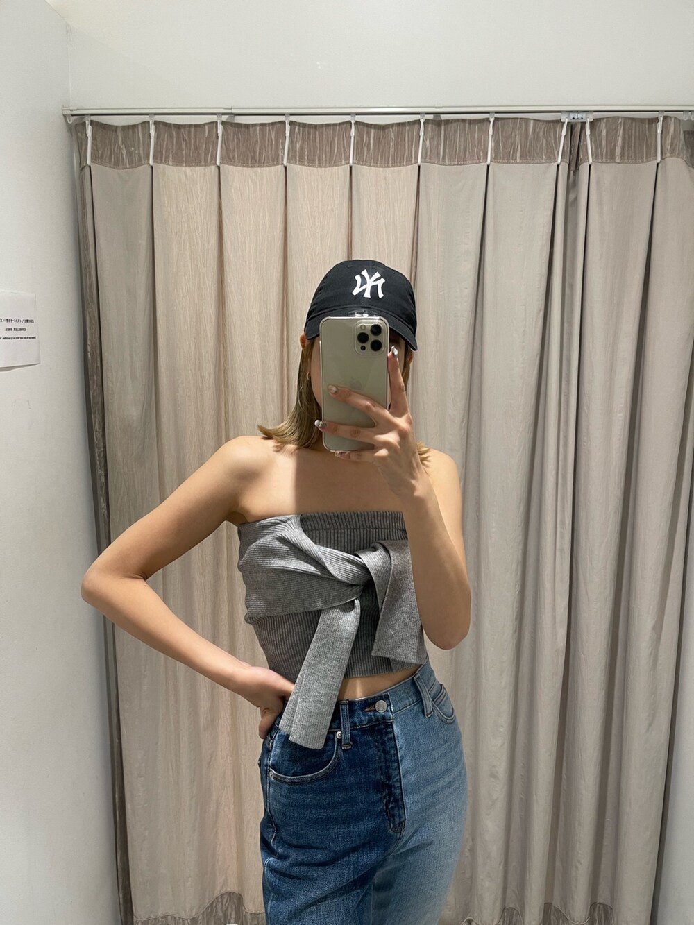 ブラック系のサンダル、グレー系のチューブトップ、ブルー系のデニムパンツを着用したレディースの春コーディネートの4枚目の写真