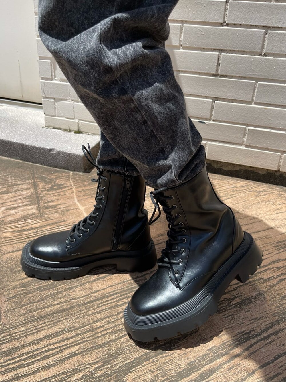 ブラック系のブーツ、ブラック系のデニムパンツ、ベージュ系のニット/セーターを着用したレディースの夏コーディネートの8枚目の写真