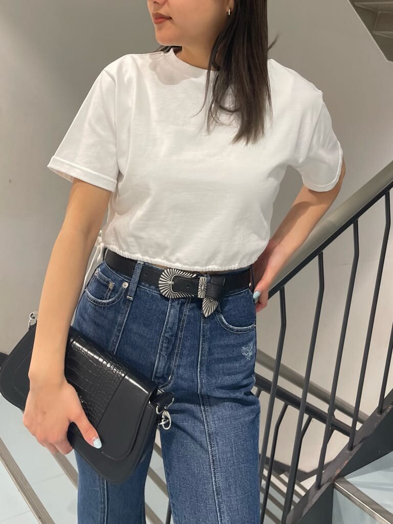 ホワイト系のTシャツ/カットソー、ブラック系のブーツ、ブルー系のデニムパンツを着用したレディースの春コーディネートの3枚目の写真