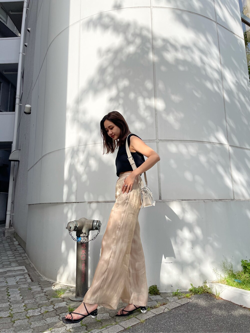 ベージュ系のその他パンツ、ブラック系のサンダルを着用したレディースの春コーディネートの5枚目の写真