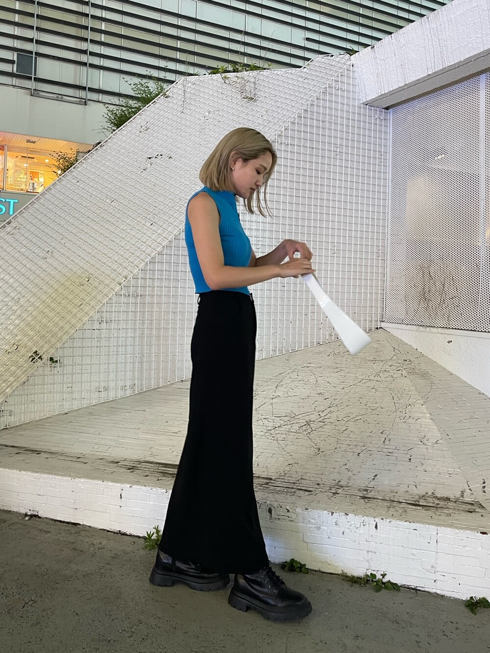 ブラック系のブーツ、ホワイト系のハンドバッグ、ブルー系のタンクトップを着用したレディースの夏コーディネートの4枚目の写真