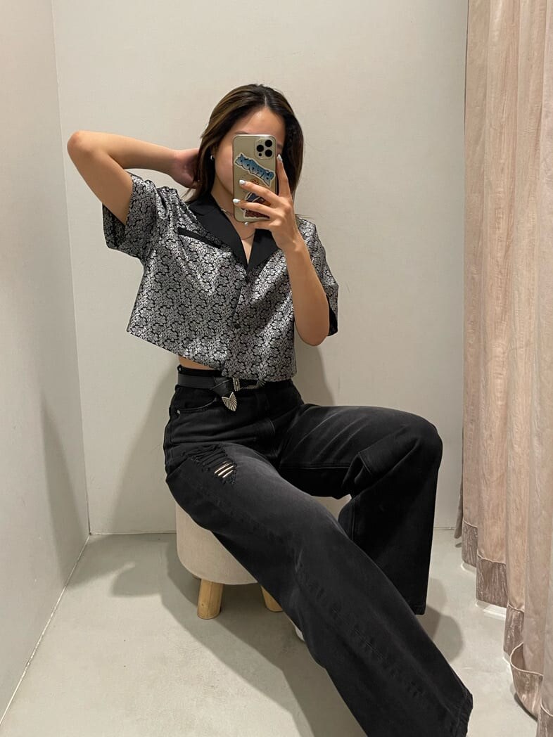 ブラック系のシャツ/ブラウス、ブラック系のデニムパンツ、ホワイト系のベルトを着用したレディースの春コーディネートの2枚目の写真