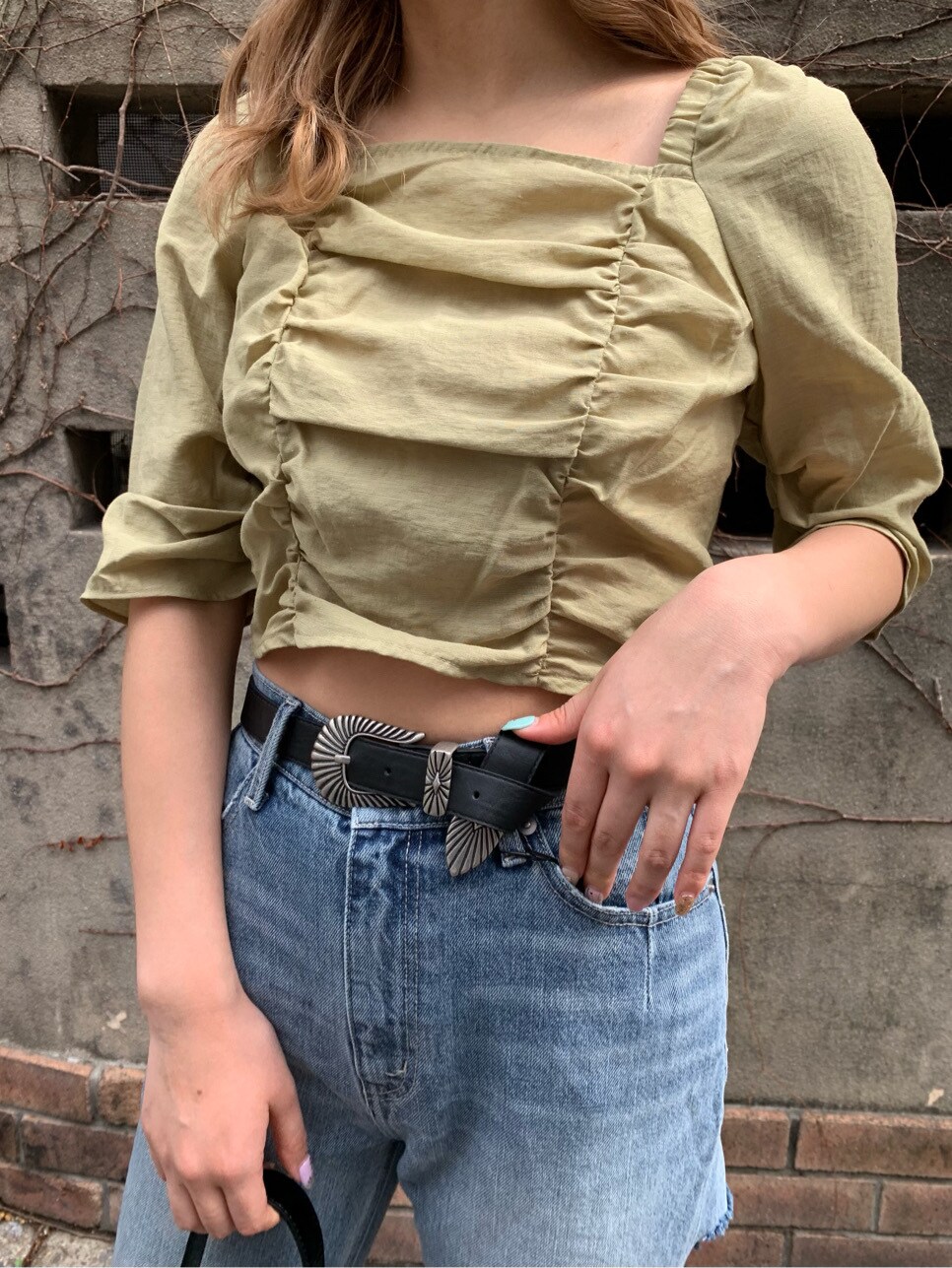 ブルー系のデニムパンツ、グリーン系のシャツ/ブラウス、ブラック系のショルダーバッグを着用したレディースの春コーディネートの6枚目の写真