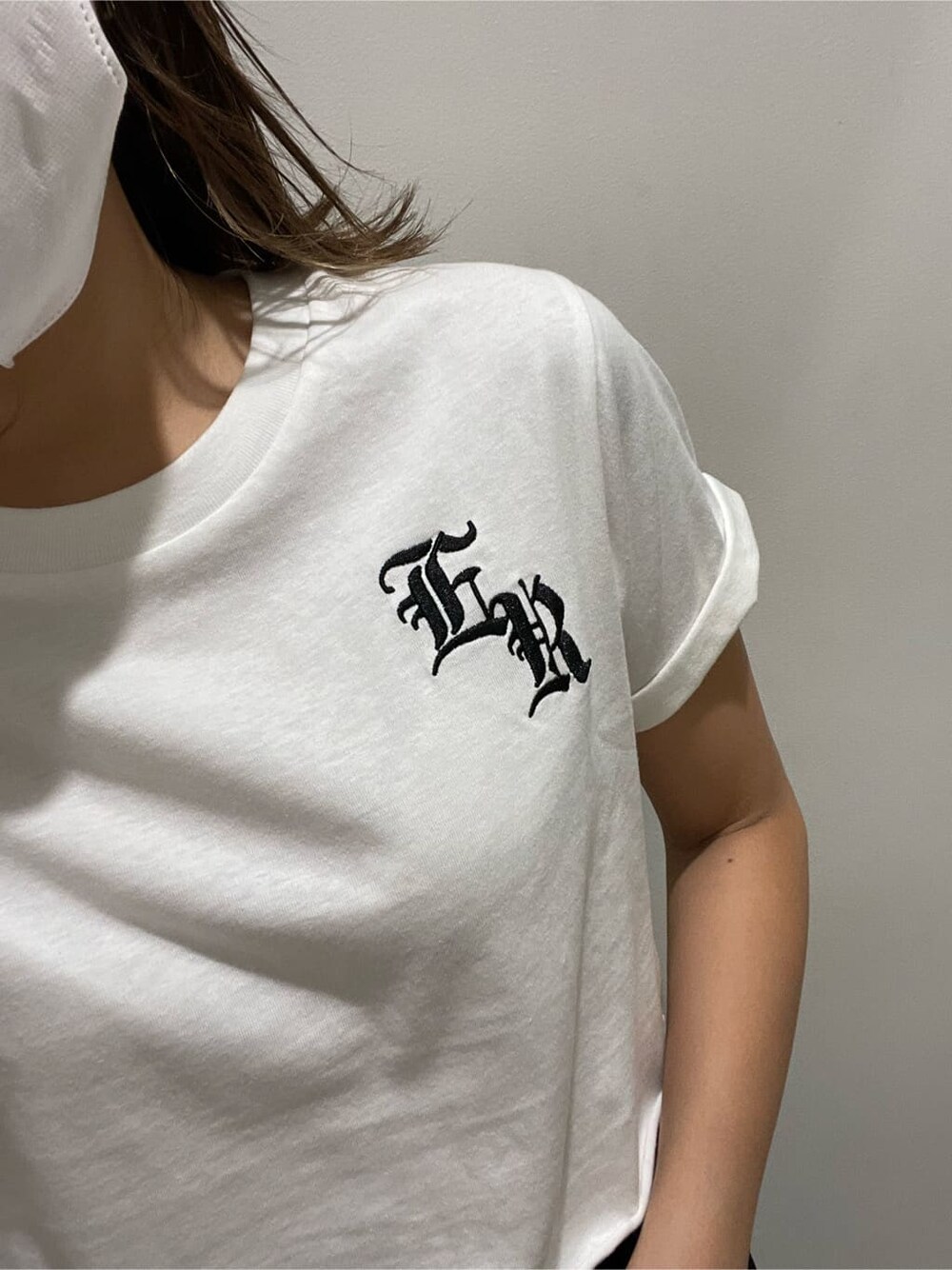 ブラック系のショルダーバッグ、ブラック系のスカート、ホワイト系のTシャツ/カットソーを着用したレディースの夏コーディネートの3枚目の写真