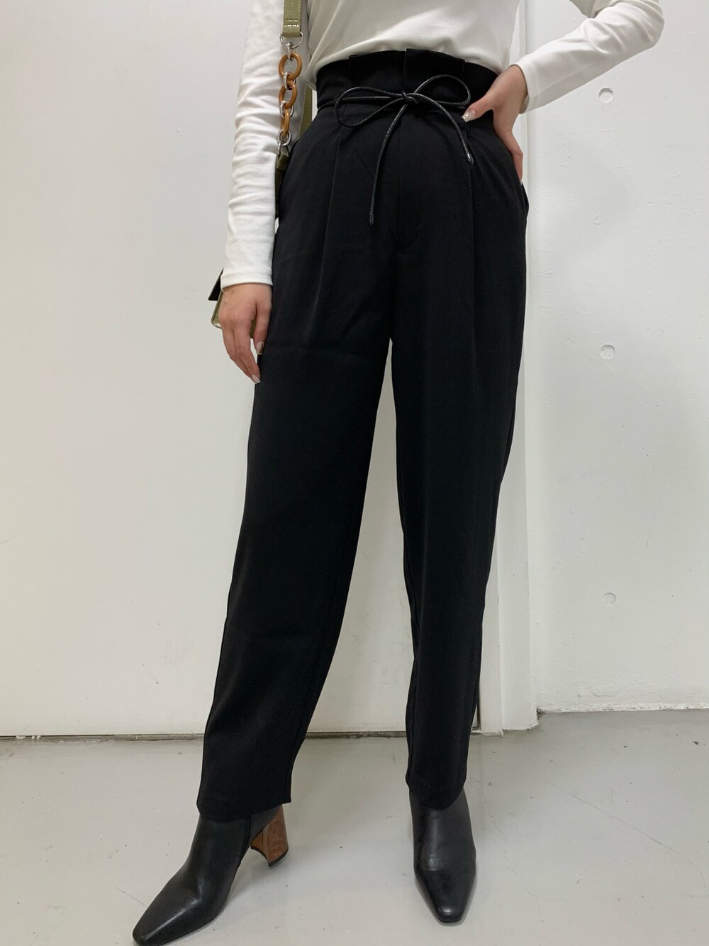 ブラック系のその他パンツ、ホワイト系のTシャツ/カットソーを着用したレディースの冬コーディネートの2枚目の写真