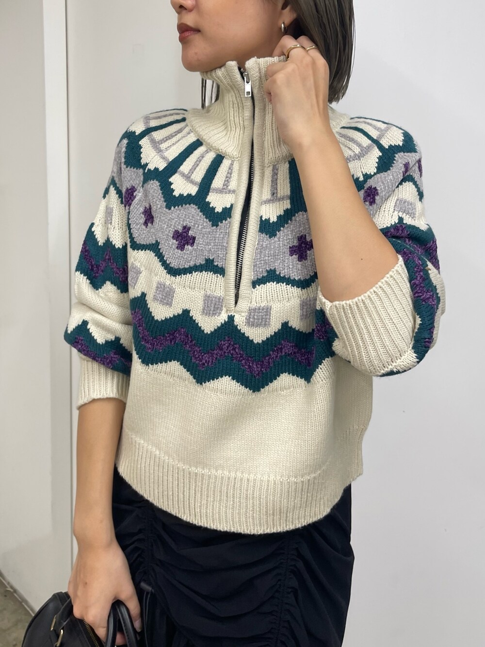 ブラック系のスカート、ホワイト系のブーツ、ホワイト系のニット/セーターを着用したレディースの秋コーディネートの5枚目の写真