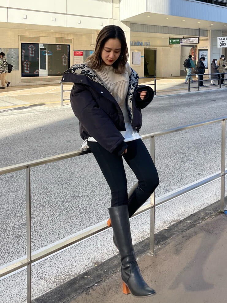 ブラック系のデニムパンツ、ブラック系のブーツ、ブラック系のダウンジャケット/コートを着用したレディースの冬コーディネートの3枚目の写真