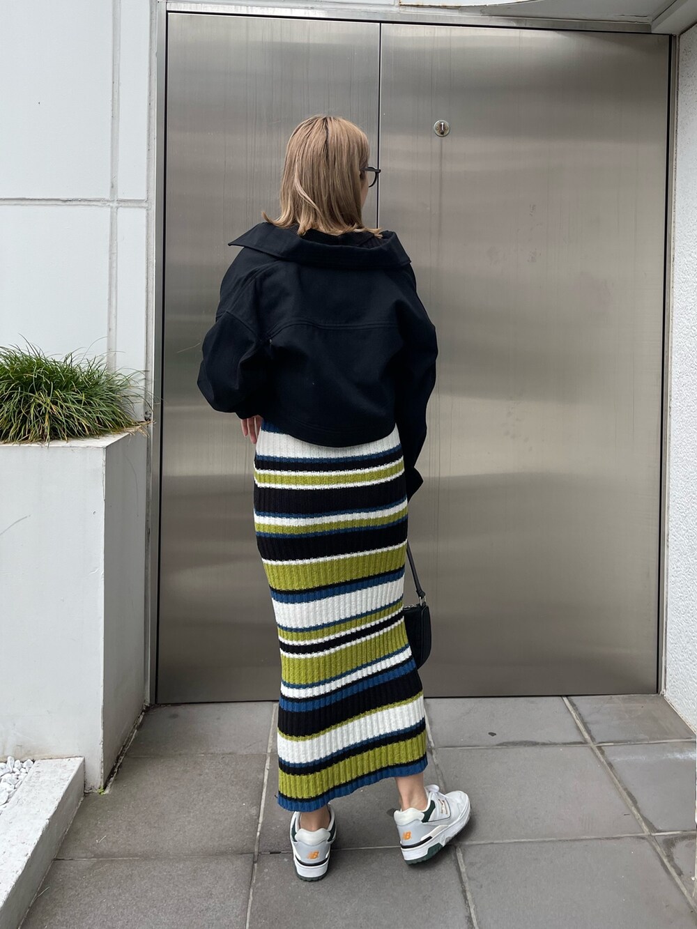 ブラック系のワンピース、ブラック系のミリタリージャケット、ブラック系のハンドバッグを着用したレディースの春コーディネートの5枚目の写真