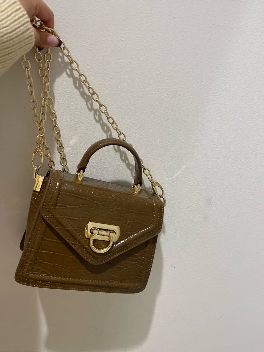 ブラック系のブーツ、ホワイト系のワンピース、ブラウン系のハンドバッグを着用したレディースの秋コーディネートの9枚目の写真