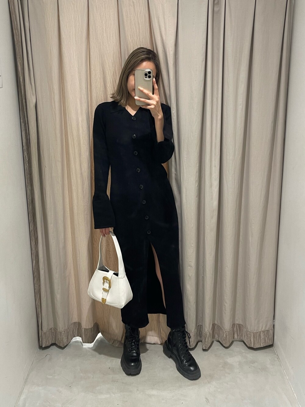 ホワイト系のブーツ、ブラック系のハンドバッグ、ブラック系のワンピースを着用したレディースの冬コーディネートの2枚目の写真