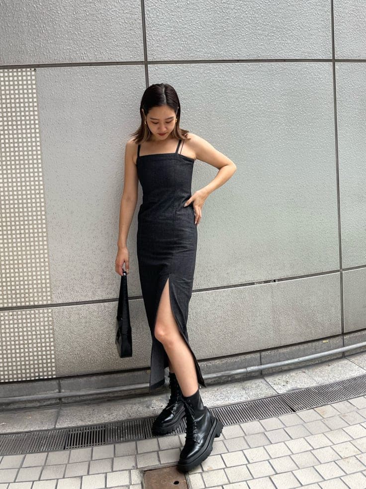 ブラック系のハンドバッグ、ブラック系のワンピース、ブラック系のブーツを着用したレディースの夏コーディネートの3枚目の写真