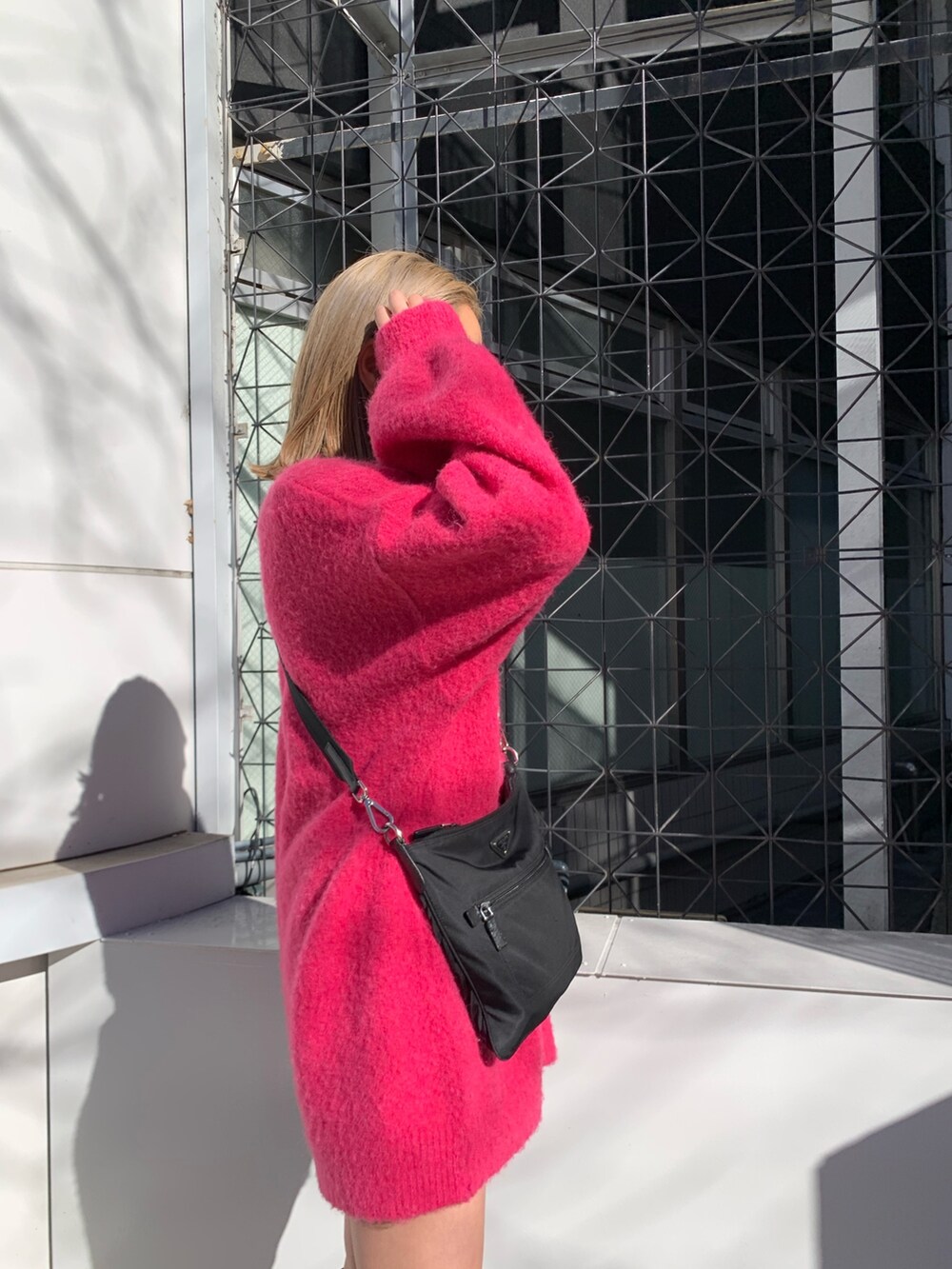 ピンク系のカーディガン/ボレロ、ホワイト系のTシャツ/カットソー、ブラック系のブーツを着用したレディースの冬コーディネートの6枚目の写真