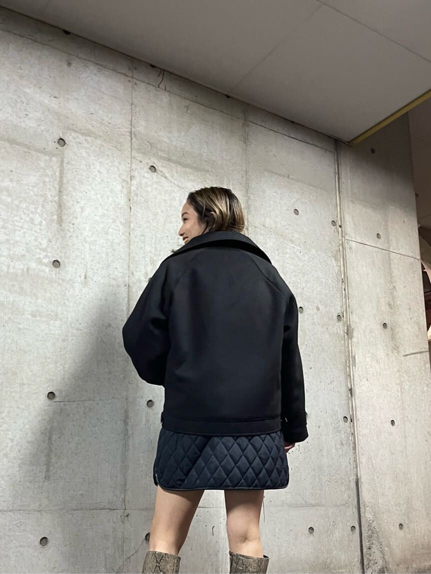 ブラック系のブルゾン、ホワイト系のニット/セーター、ブラック系のスカートを着用したレディースの秋コーディネートの4枚目の写真