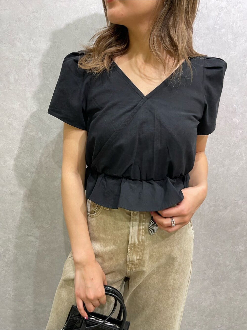 ブラック系のシャツ/ブラウス、ベージュ系のデニムパンツ、ホワイト系のサンダルを着用したレディースの春コーディネートの6枚目の写真