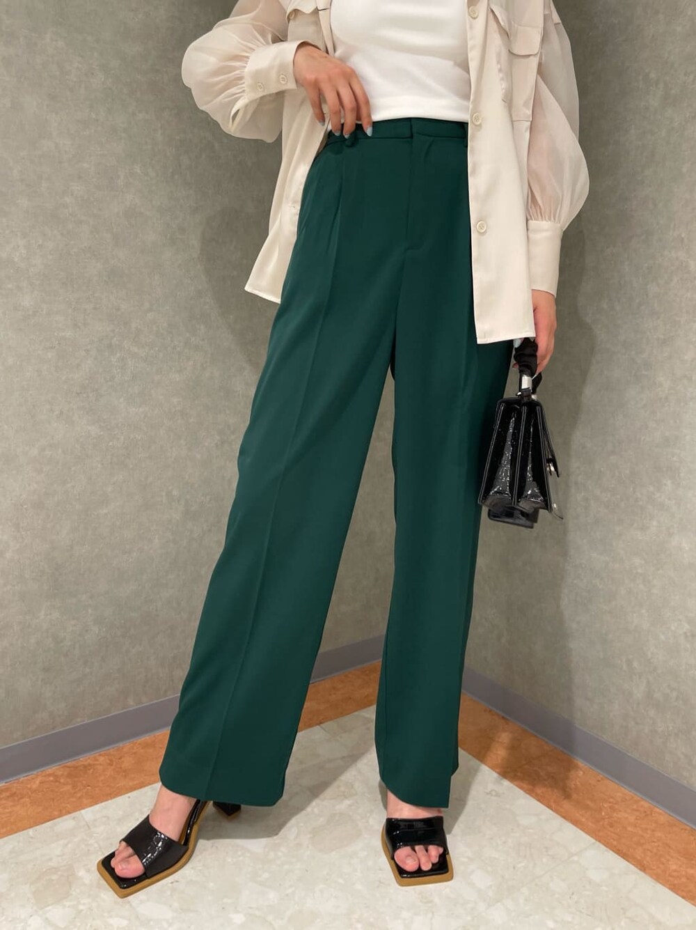 ホワイト系のタンクトップ、グリーン系のスラックス、ホワイト系のシャツ/ブラウスを着用したレディースの春コーディネートの6枚目の写真