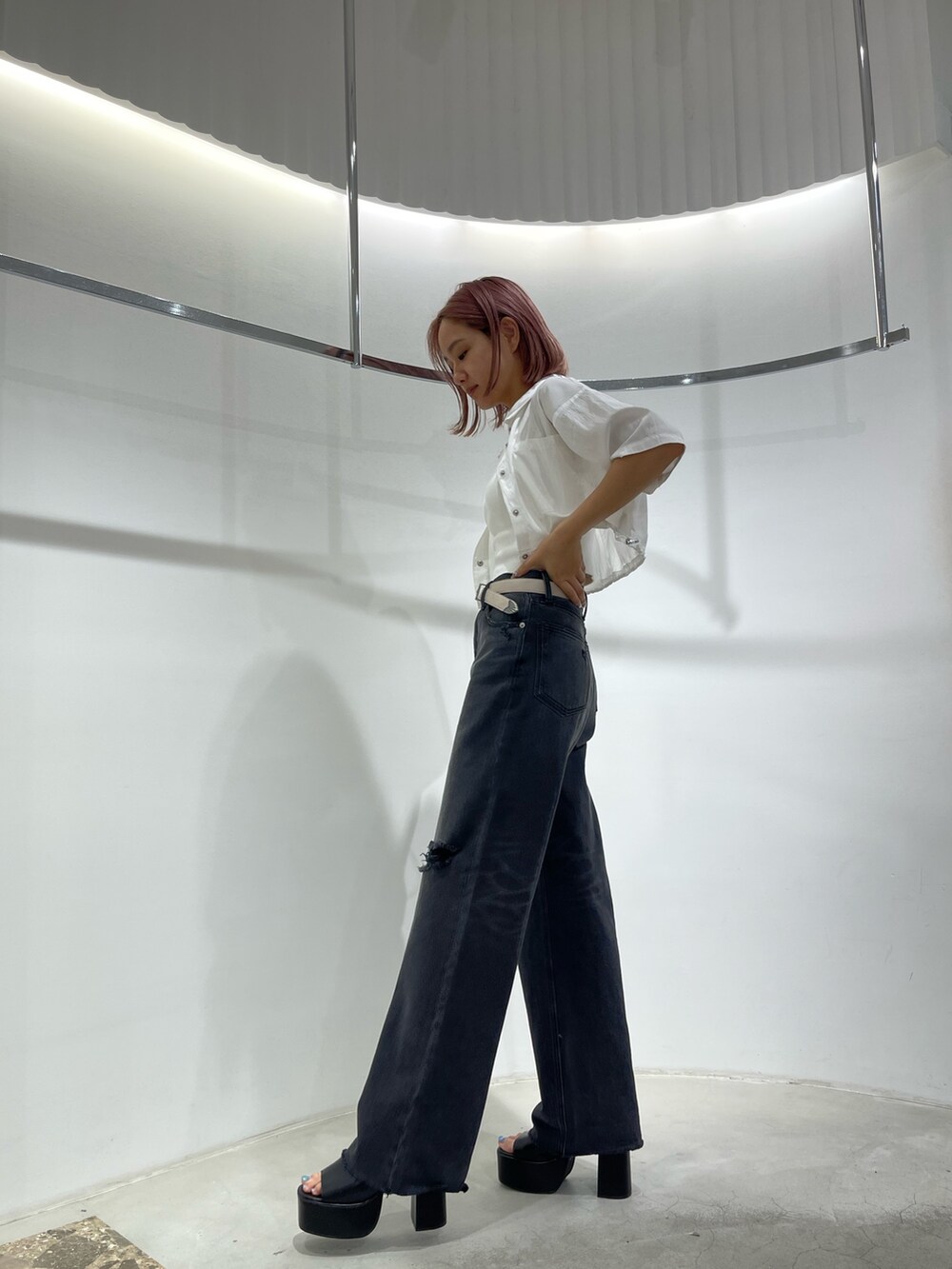 ブラック系のデニムパンツ、ブラック系のサンダル、ホワイト系のキャミソールを着用したレディースの夏コーディネートの2枚目の写真