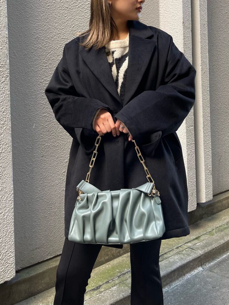 ブラック系のブーツ、ブラック系のその他アウター、グリーン系のショルダーバッグを着用したレディースの秋コーディネートの7枚目の写真