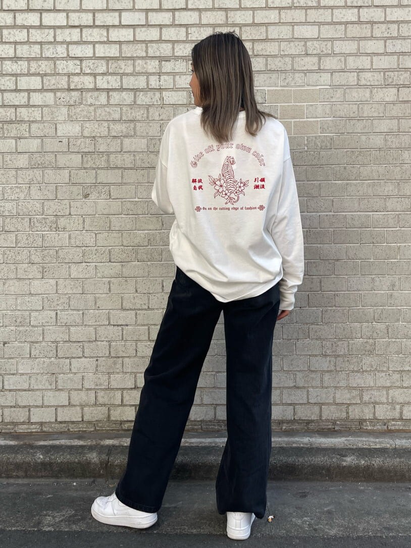 ブラック系のデニムパンツ、ホワイト系のTシャツ/カットソー、ホワイト系のベルトを着用したレディースの冬コーディネートの3枚目の写真