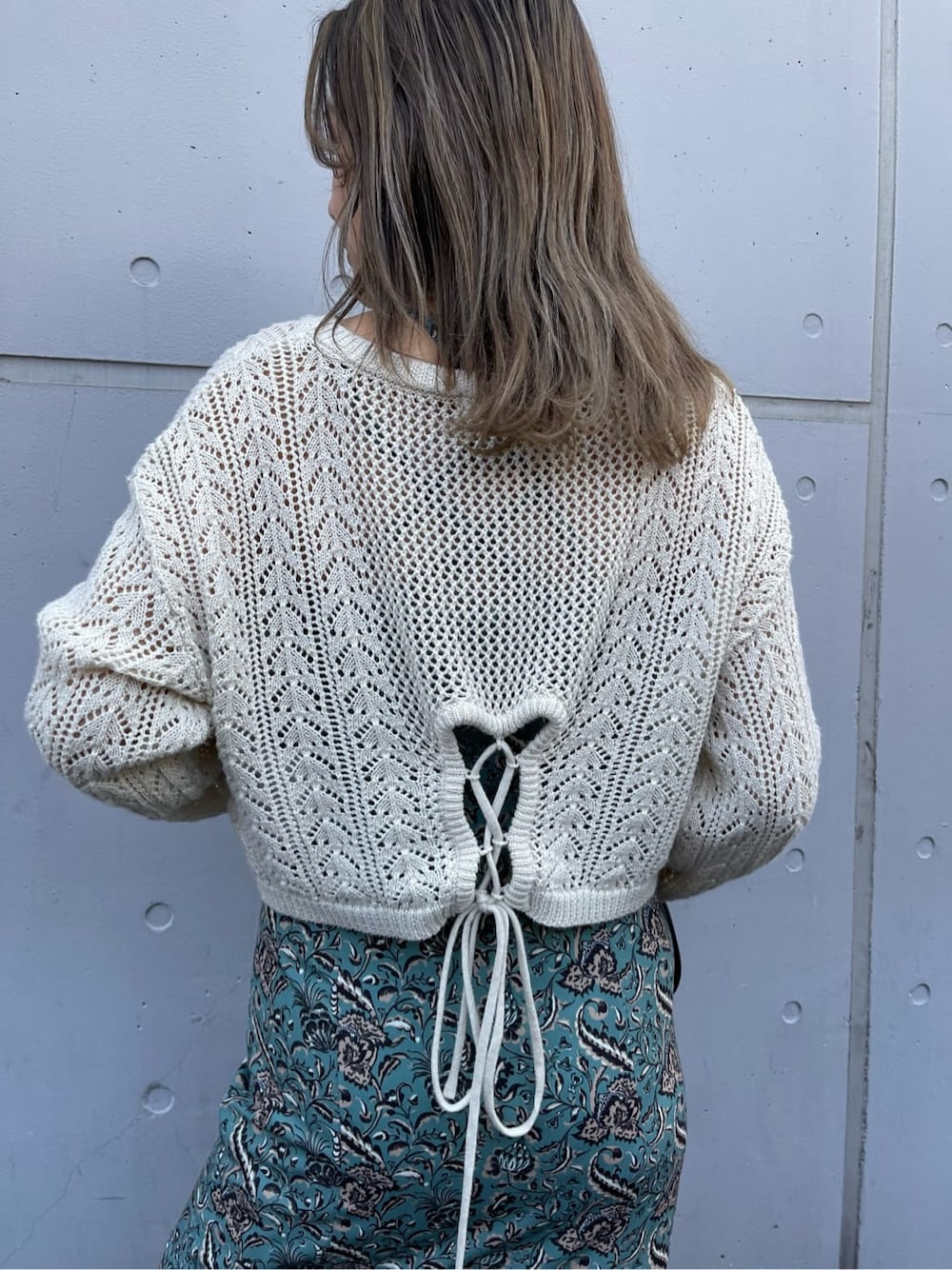 ブラック系のブーツ、グリーン系のワンピース、ホワイト系のニット/セーターを着用したレディースの春コーディネートの6枚目の写真