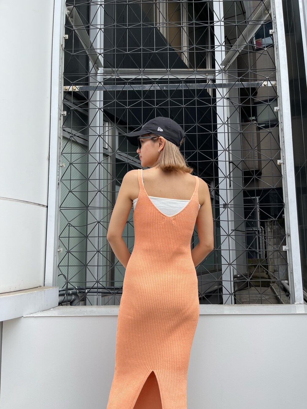 オレンジ系のワンピース、ブラック系のハンドバッグを着用したレディースの春コーディネートの8枚目の写真