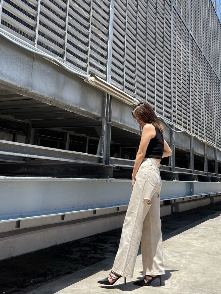 ブラック系のサンダル、ベージュ系のデニムパンツ、ブラック系のタンクトップを着用したレディースの夏コーディネートの2枚目の写真