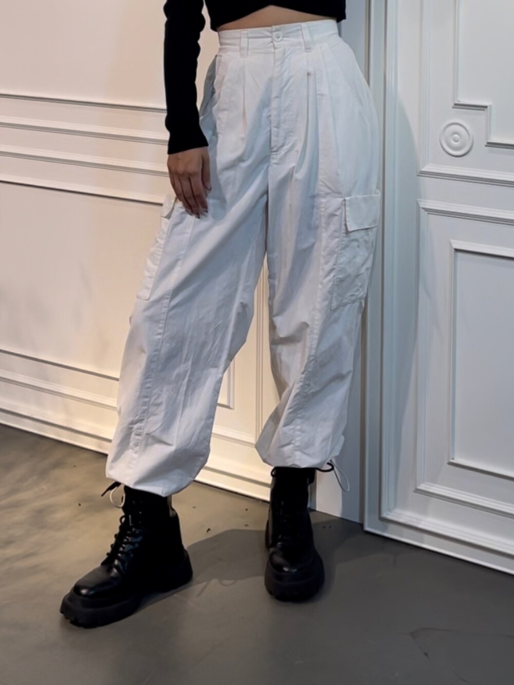 ホワイト系のカーゴパンツ、ブラック系のブーツ、ブラック系のTシャツ/カットソーを着用したレディースの秋コーディネートの3枚目の写真