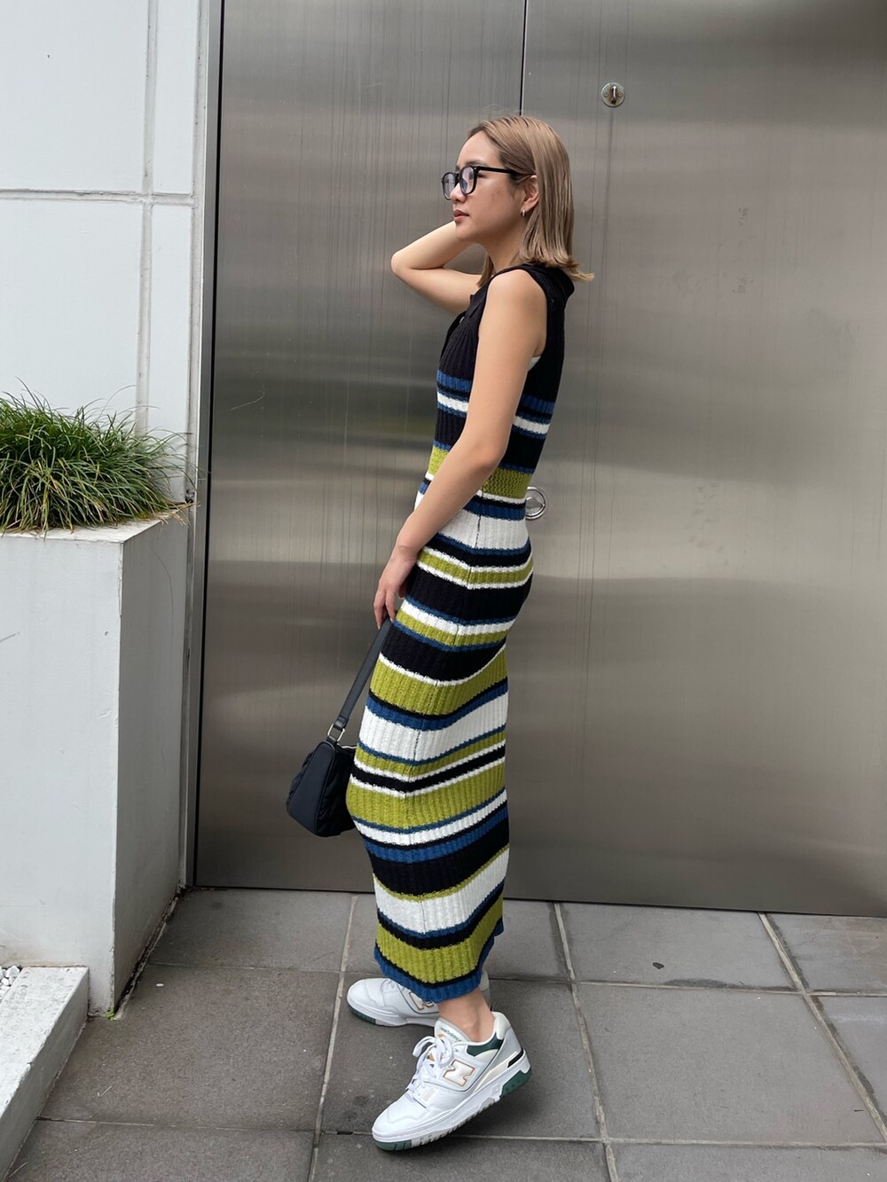 ブラック系のワンピース、ブラック系のハンドバッグを着用したレディースの春コーディネートの2枚目の写真