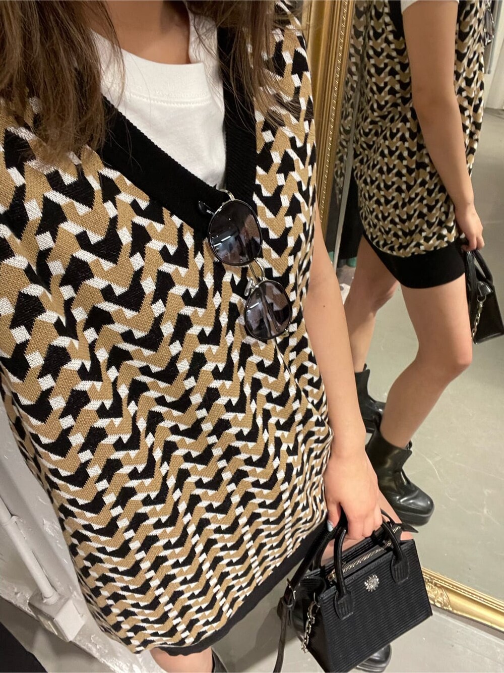 ブラック系のブーツ、ベージュ系のデニムパンツ、ブラック系のニット/セーターを着用したレディースの春コーディネートの6枚目の写真