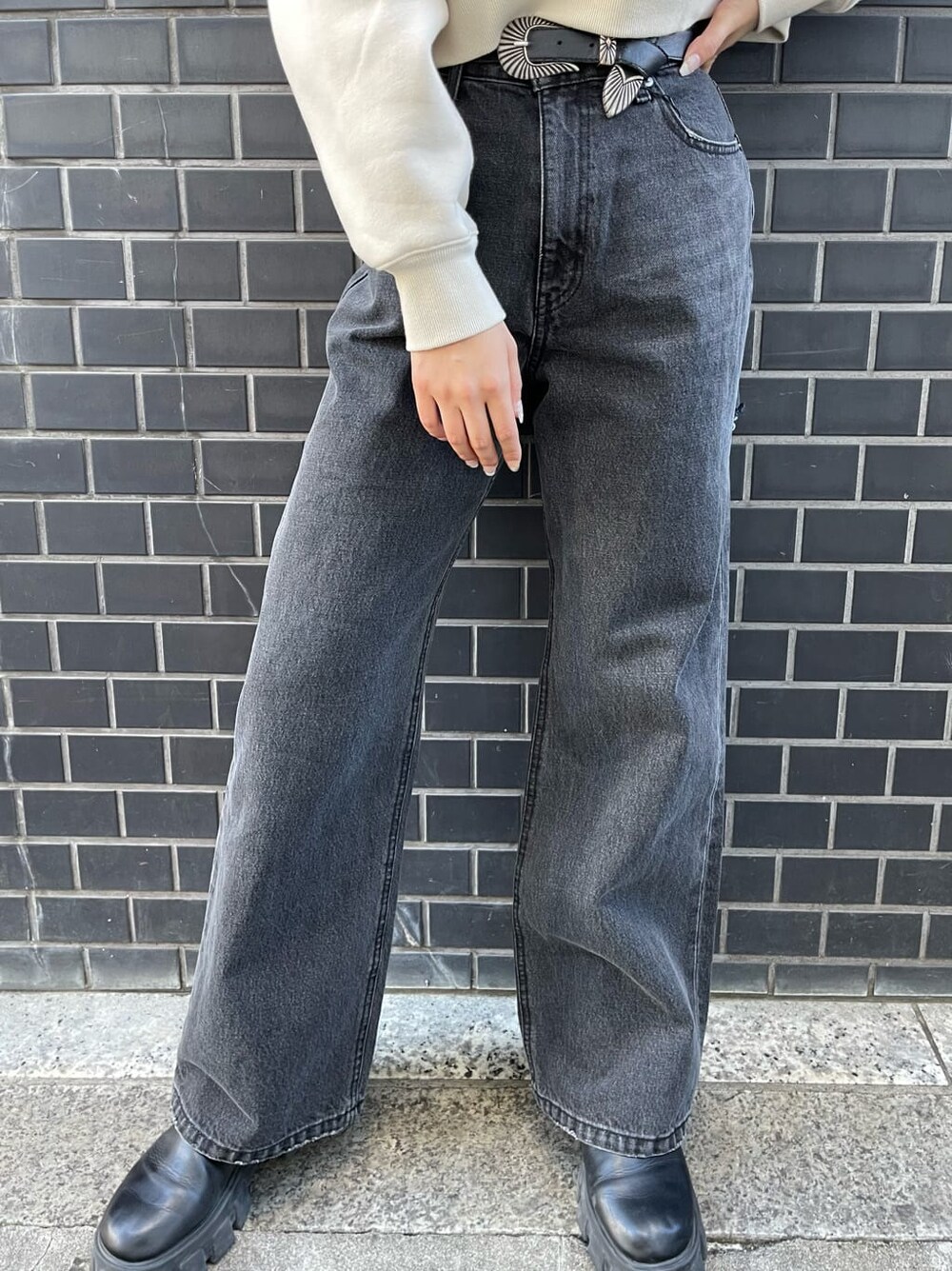 ブラック系のデニムパンツ、ブラック系のブーツ、ホワイト系のスウェットを着用したレディースの冬コーディネートの8枚目の写真