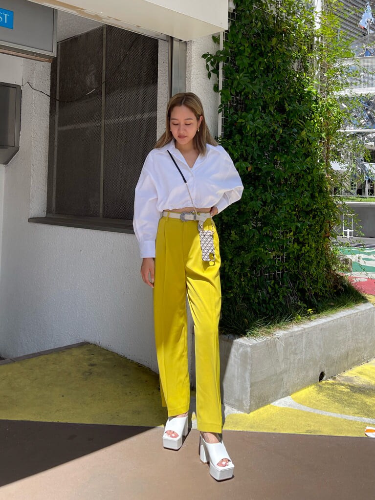 ホワイト系のサンダル、ホワイト系のシャツ/ブラウス、イエロー系のスラックスを着用したレディースの夏コーディネートの2枚目の写真