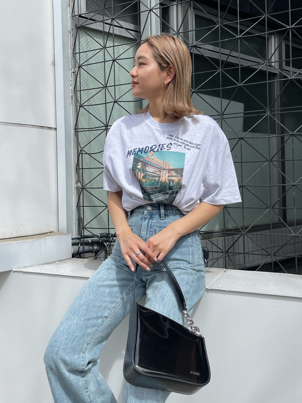 グレー系のTシャツ/カットソー、ブルー系のデニムパンツ、ブラック系のサンダルを着用したレディースの春コーディネートの3枚目の写真