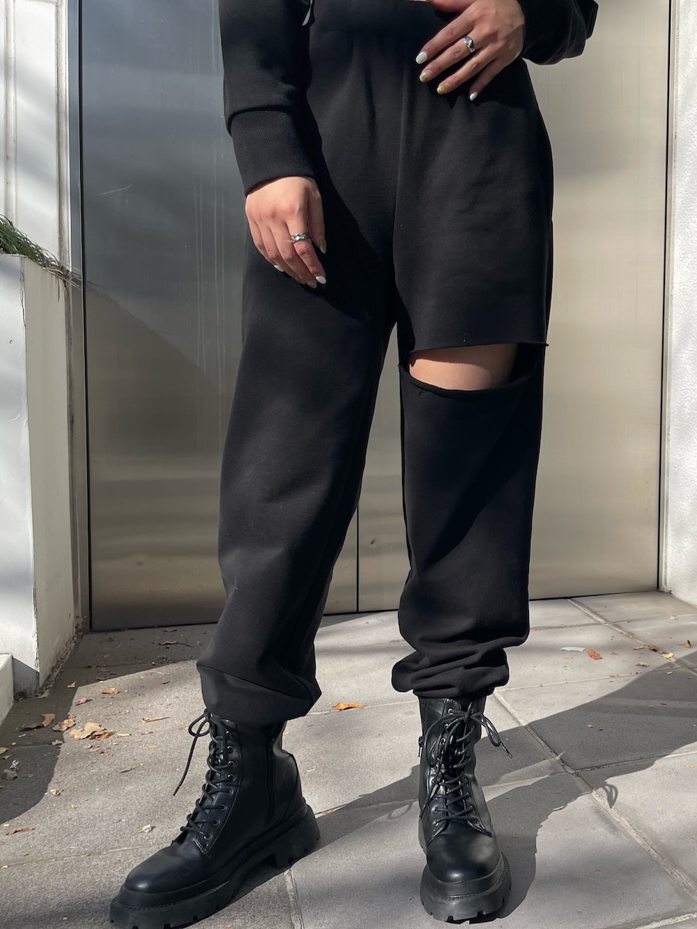 ブラック系のスウェットパンツ、ブラック系のブーツ、ブラック系のTシャツ/カットソーを着用したレディースの冬コーディネートの7枚目の写真