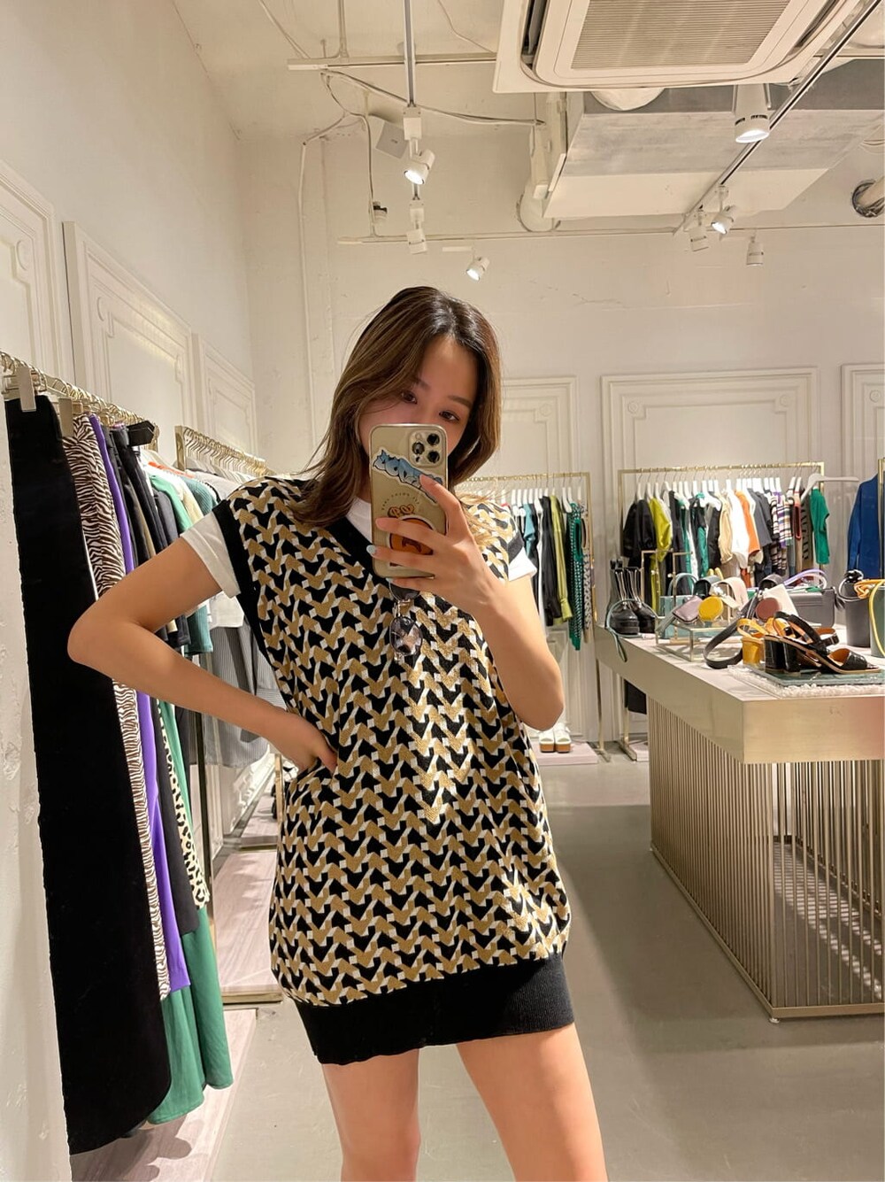 ブラック系のブーツ、ベージュ系のデニムパンツ、ブラック系のニット/セーターを着用したレディースの春コーディネートの3枚目の写真