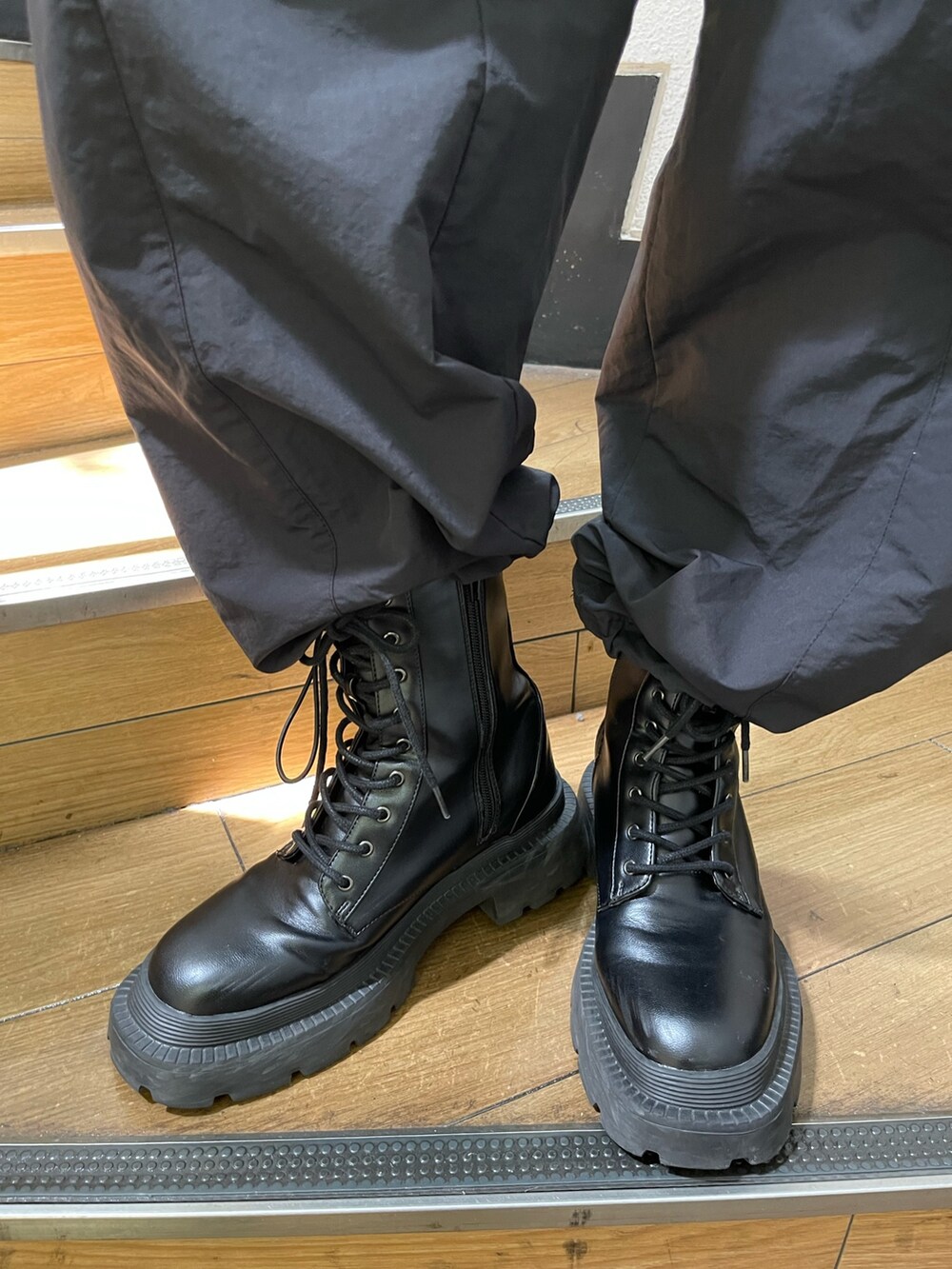 ブラック系のカーゴパンツ、ブラック系のブーツ、ブラック系のカーディガン/ボレロを着用したレディースの秋コーディネートの7枚目の写真