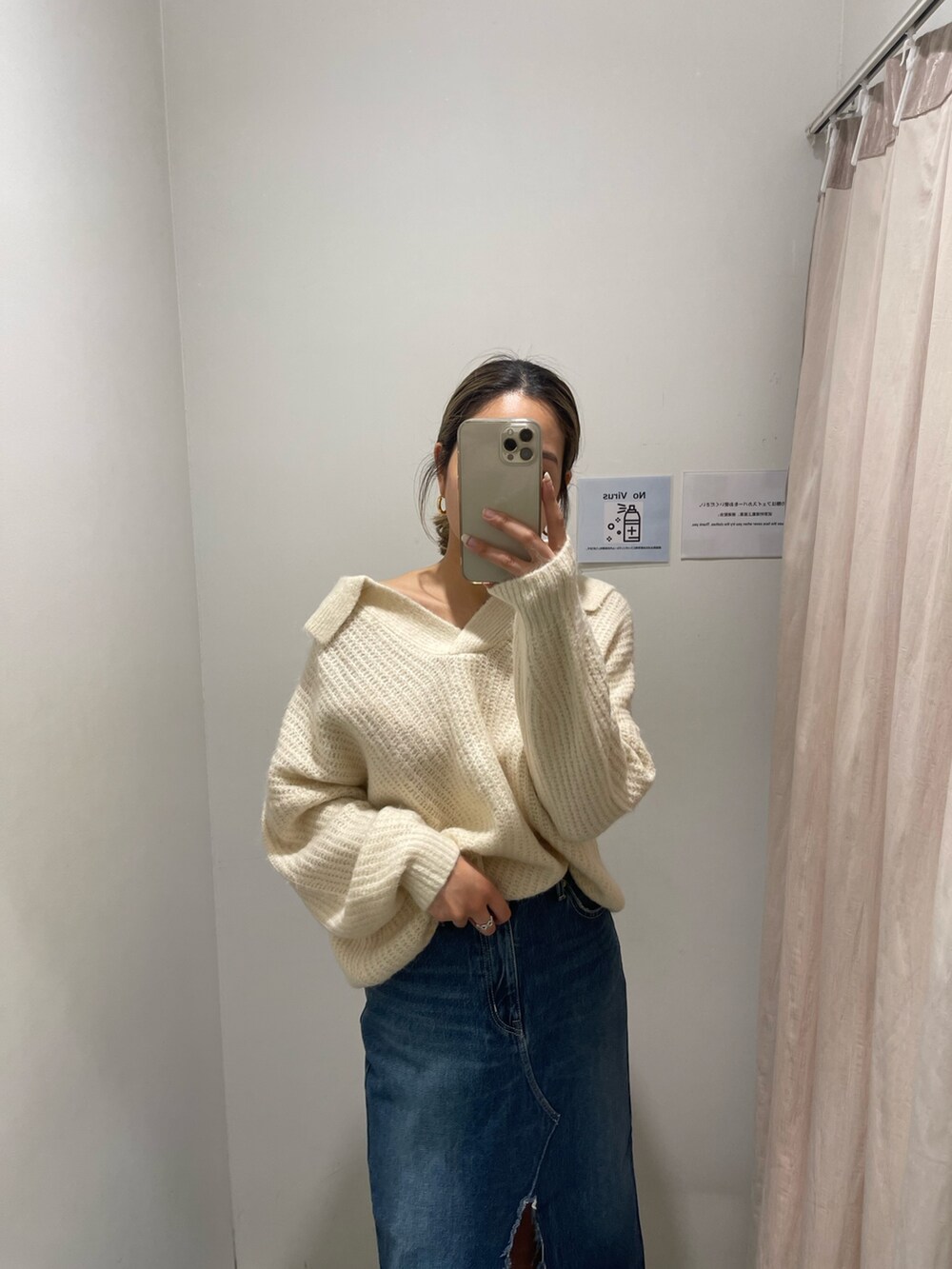 ブルー系のデニムスカート、ホワイト系のニット/セーター、ブラック系のブーツを着用したレディースの秋コーディネートの3枚目の写真