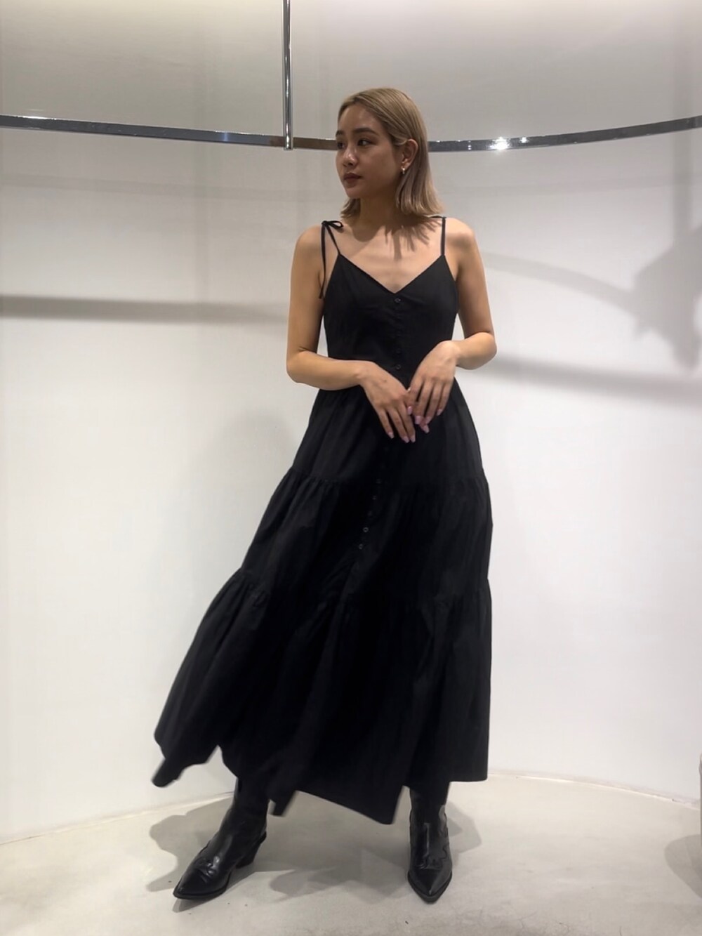 ブラック系のワンピース、ブラック系のブーツを着用したレディースの夏コーディネートの2枚目の写真