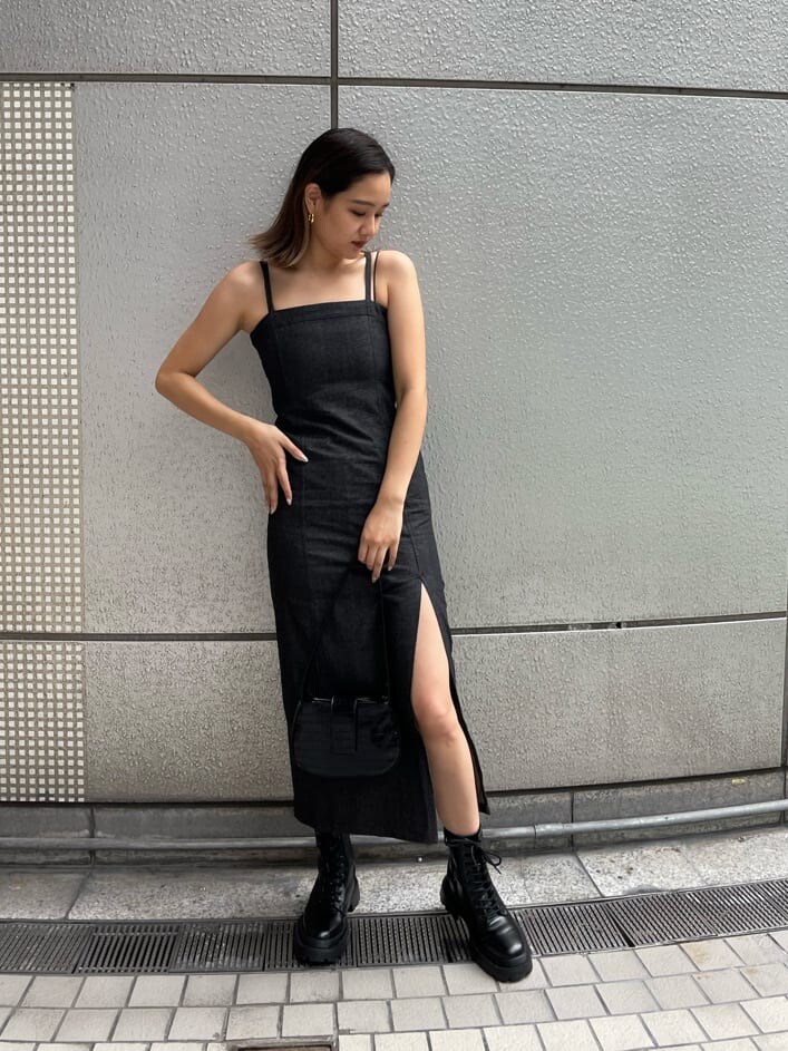 ブラック系のハンドバッグ、ブラック系のワンピース、ブラック系のブーツを着用したレディースの夏コーディネートの5枚目の写真