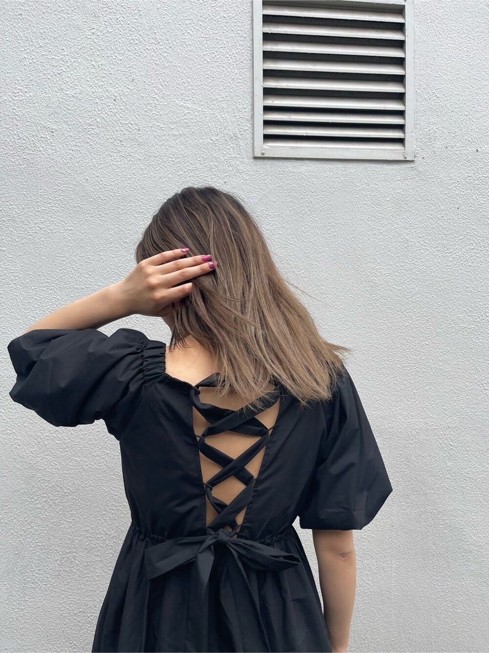 グリーン系のボストンバッグ、ブラック系のワンピース、ホワイト系のサンダルを着用したレディースの春コーディネートの6枚目の写真