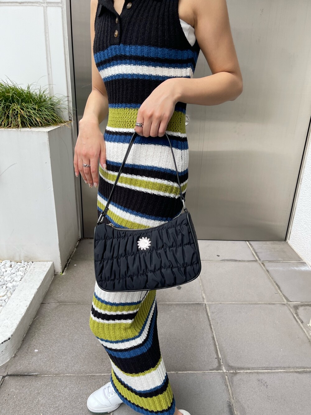 ブラック系のワンピース、ブラック系のハンドバッグを着用したレディースの春コーディネートの4枚目の写真