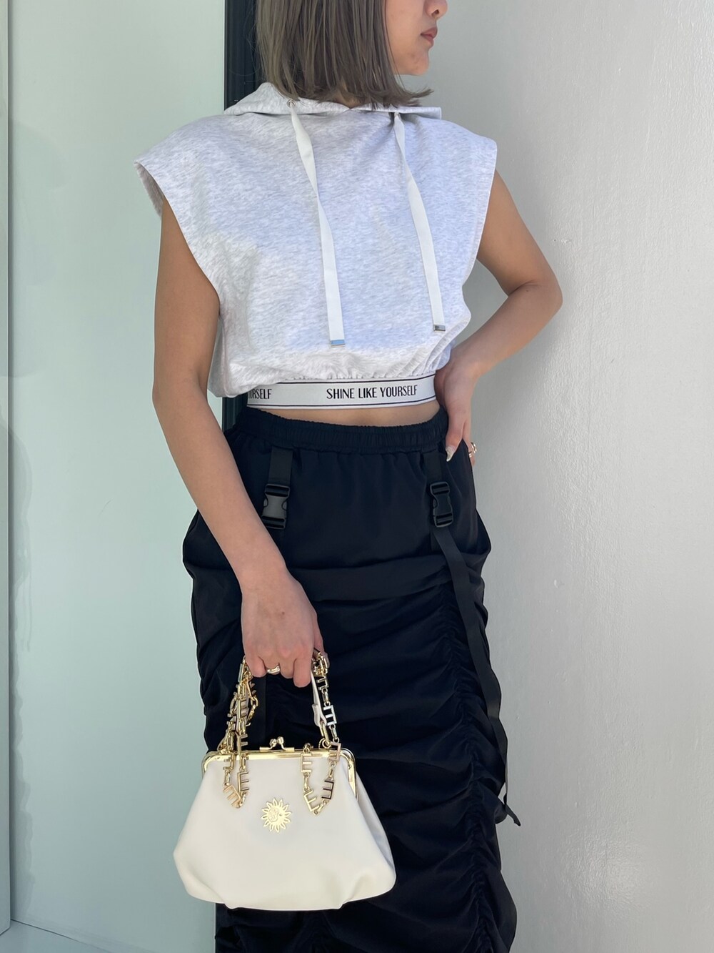 ホワイト系のブーツ、グレー系のスウェット、ホワイト系のショルダーバッグを着用したレディースの春コーディネートの5枚目の写真