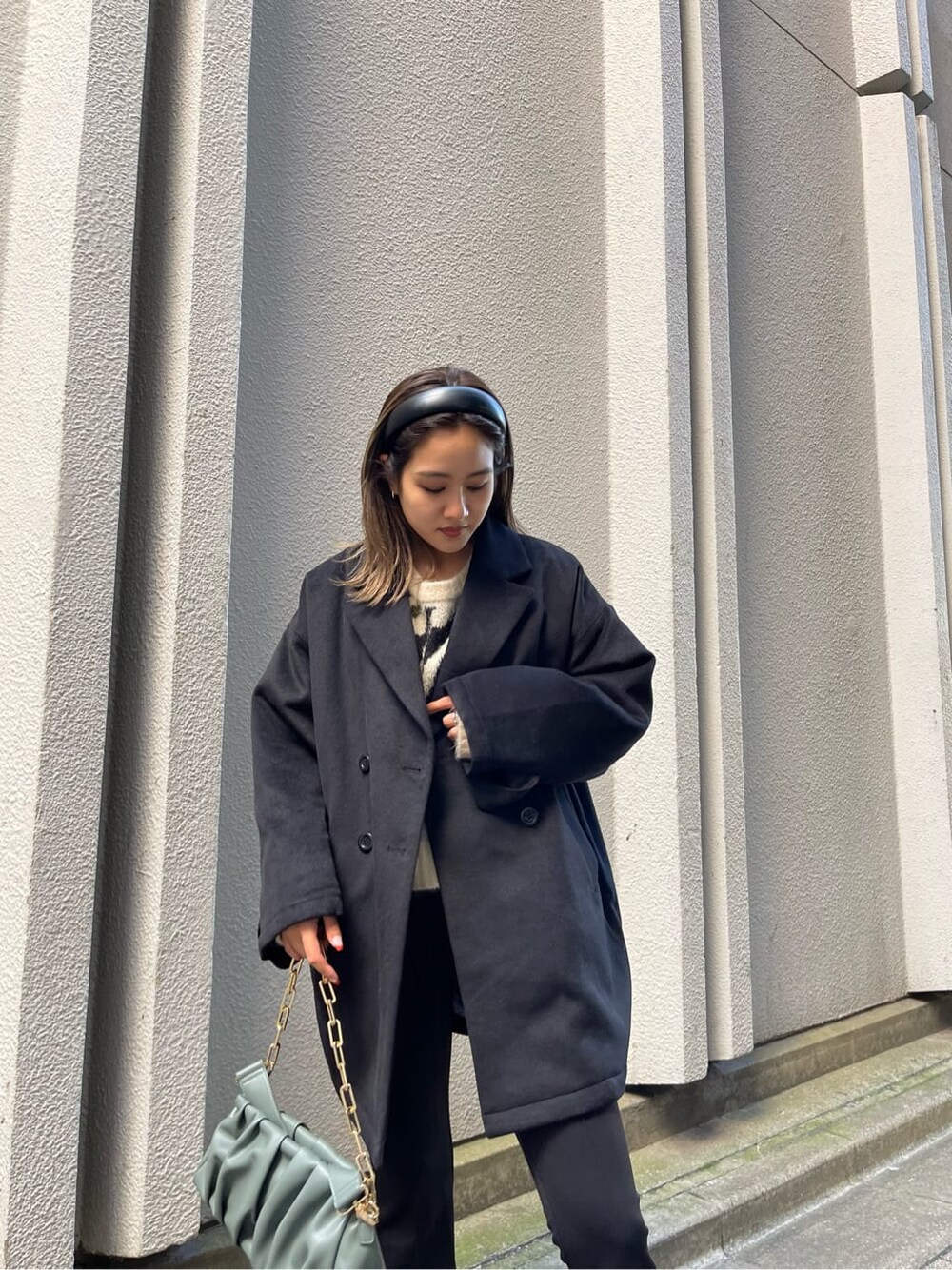 ブラック系のブーツ、ブラック系のその他アウター、グリーン系のショルダーバッグを着用したレディースの秋コーディネートの5枚目の写真