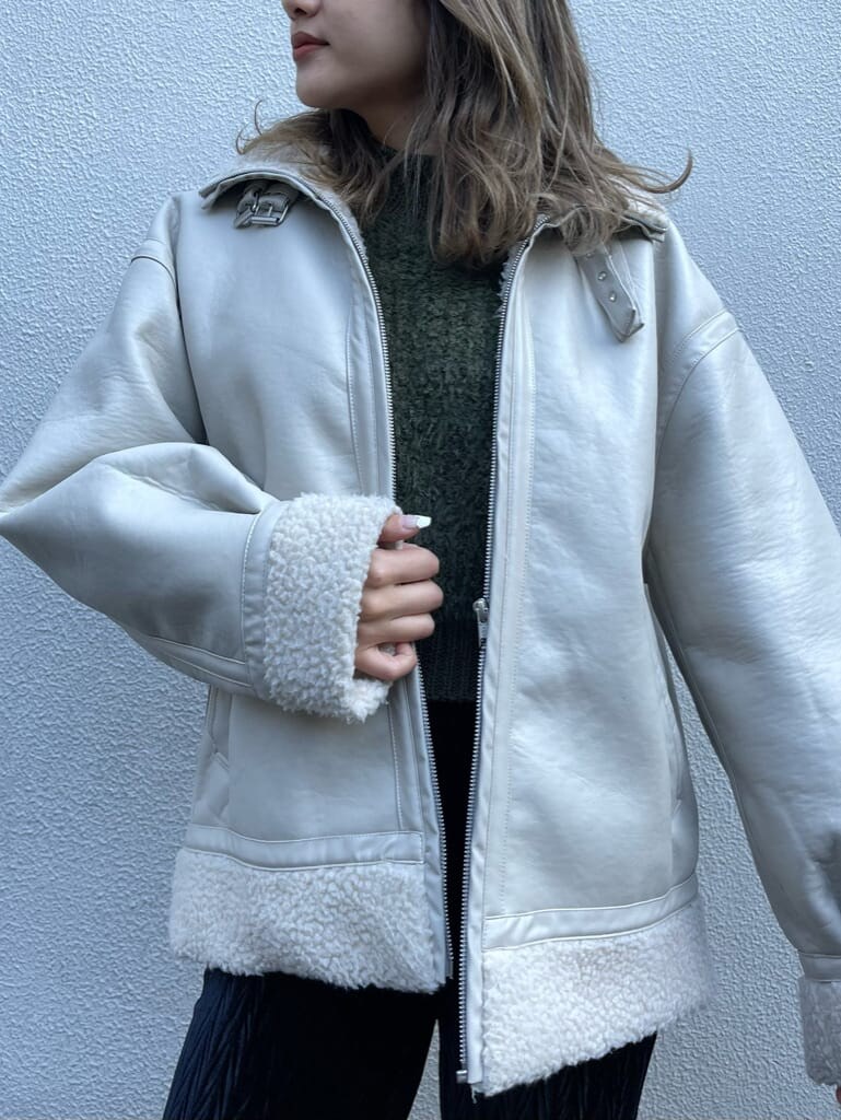 ホワイト系のブルゾン、ベージュ系のニット/セーター、ブラック系のその他パンツを着用したレディースの冬コーディネートの8枚目の写真