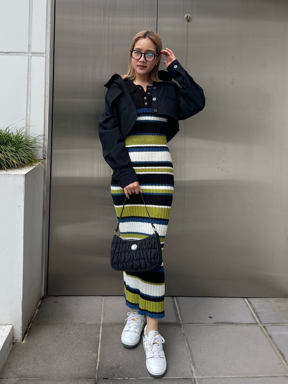 ブラック系のワンピース、ブラック系のミリタリージャケット、ブラック系のハンドバッグを着用したレディースの春コーディネートの2枚目の写真