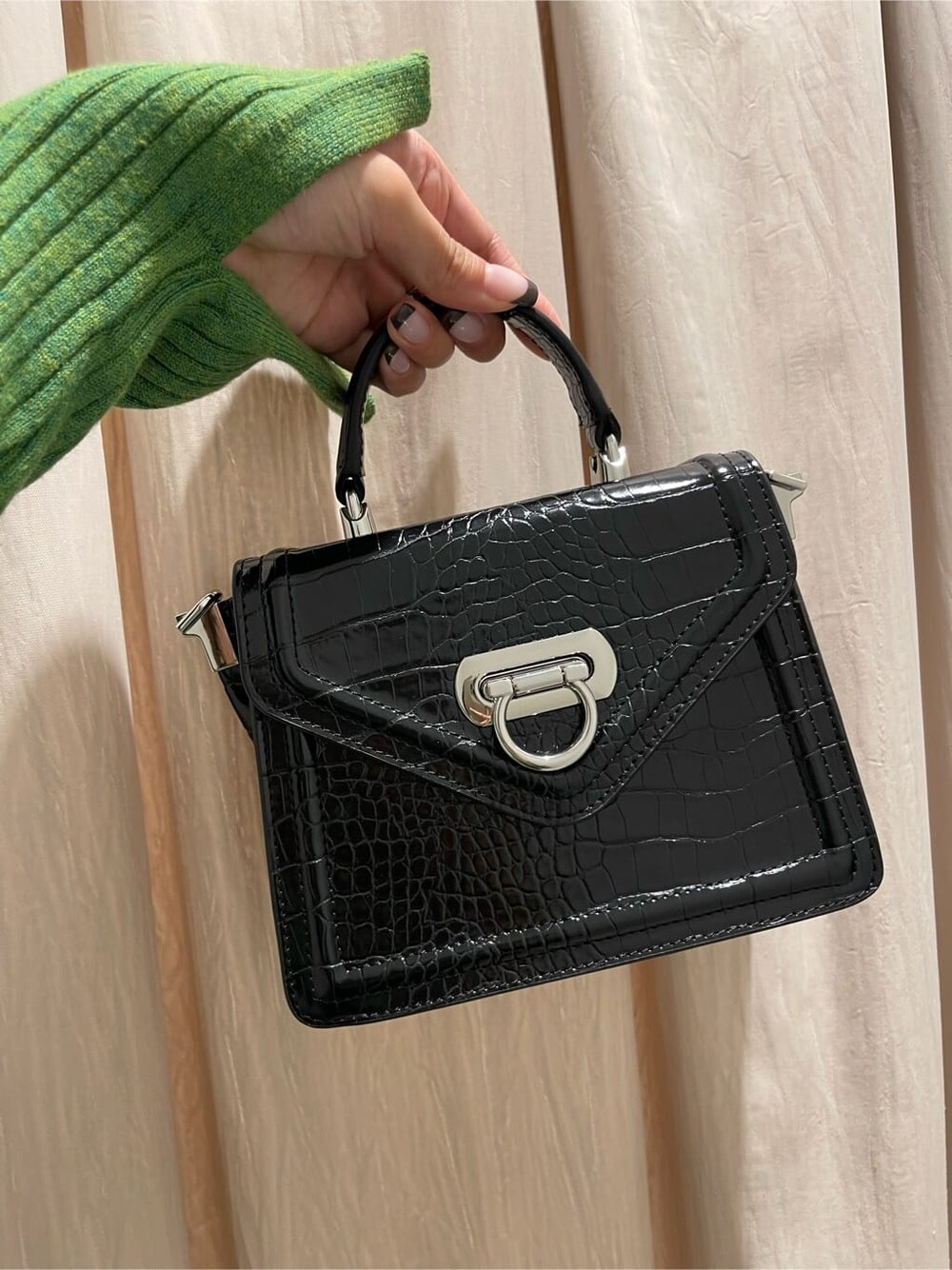 ブラック系のブーツ、グリーン系のニット/セーター、ブラック系のハンドバッグを着用したレディースの秋コーディネートの8枚目の写真