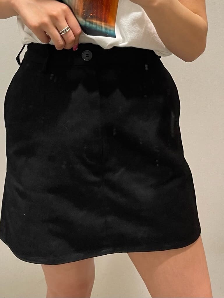 ブラック系のスカート、ホワイト系のTシャツ/カットソー、ブラック系のブーツを着用したレディースの春コーディネートの7枚目の写真