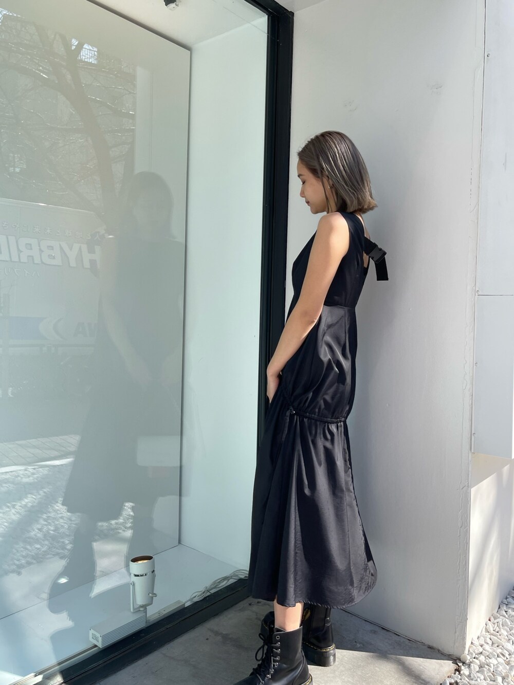 ブラック系のブーツ、ブルー系のショルダーバッグ、ブラック系のワンピースを着用したレディースの春コーディネートの3枚目の写真