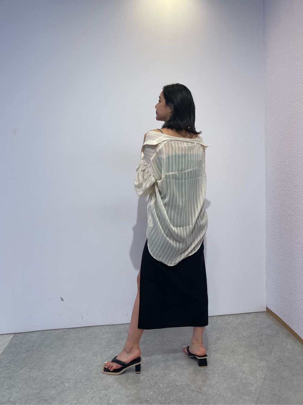 ブラック系のスカート、ホワイト系のシャツ/ブラウス、ブラック系のサンダルを着用したレディースの夏コーディネートの5枚目の写真