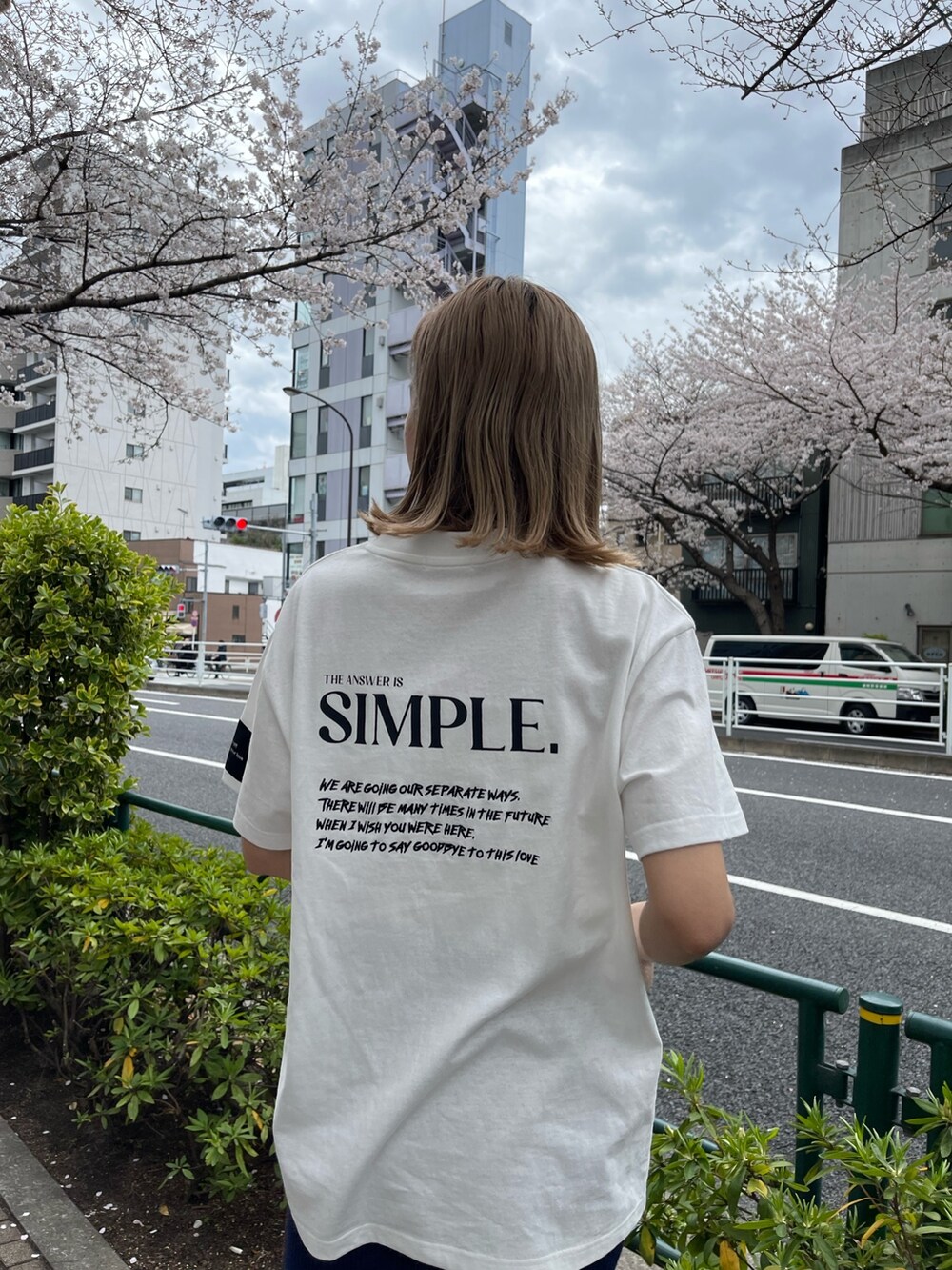 ブラック系のショルダーバッグ、ホワイト系のTシャツ/カットソー、ブルー系のスカートを着用したレディースの春コーディネートの9枚目の写真